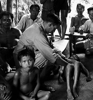 Julián de Zulueta, el «Señor de los Mosquitos», palpando el bazo a un niño en un examen de malaria  en Sarawak (Malasia), 1953.